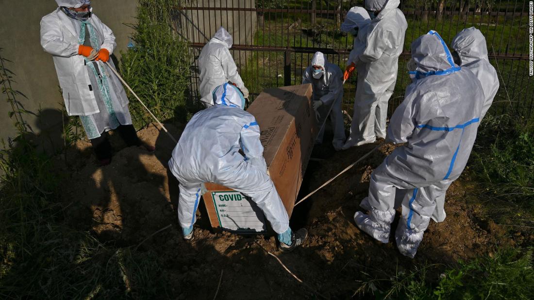 On May 21, people lower the coffin of a woman who died from the coronavirus in Srinagar, India.